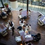 A server brings food to a table as people dine at a restaurant in Vancouver on Tuesday, September 21, 2021. THE CANADIAN PRESS/Darryl Dyck