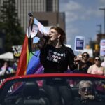 Parade grand marshal Fae Johnstone calls out chants through a megaphone during the Capital Pride Parade in Ottawa on Sunday, Aug. 27, 2023. THE CANADIAN PRESS/Justin Tang