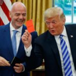 FILE - President Donald Trump holds up a red card during a meeting with FIFA president Gianni Infantino in the Oval Office of the White House, Tuesday, Aug. 28, 2018, in Washington. (AP Photo/Evan Vucci, File)