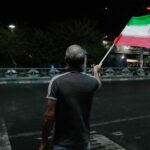 A pro-government demonstrator waves an Iranian flag in a gathering commemorating the late Iranian Supreme Leader Ayatollah Ali Khamenei at a square in Tehran, Iran, Saturday, July 11, 2026. (AP Photo/Vahid Salemi)