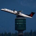 An Air Canada Express Dash 8-400 aircraft takes off from Vancouver International Airport, in Richmond, B.C., as Grouse Mountain is seen in the distance on Friday, July 31, 2026. THE CANADIAN PRESS/Darryl Dyck